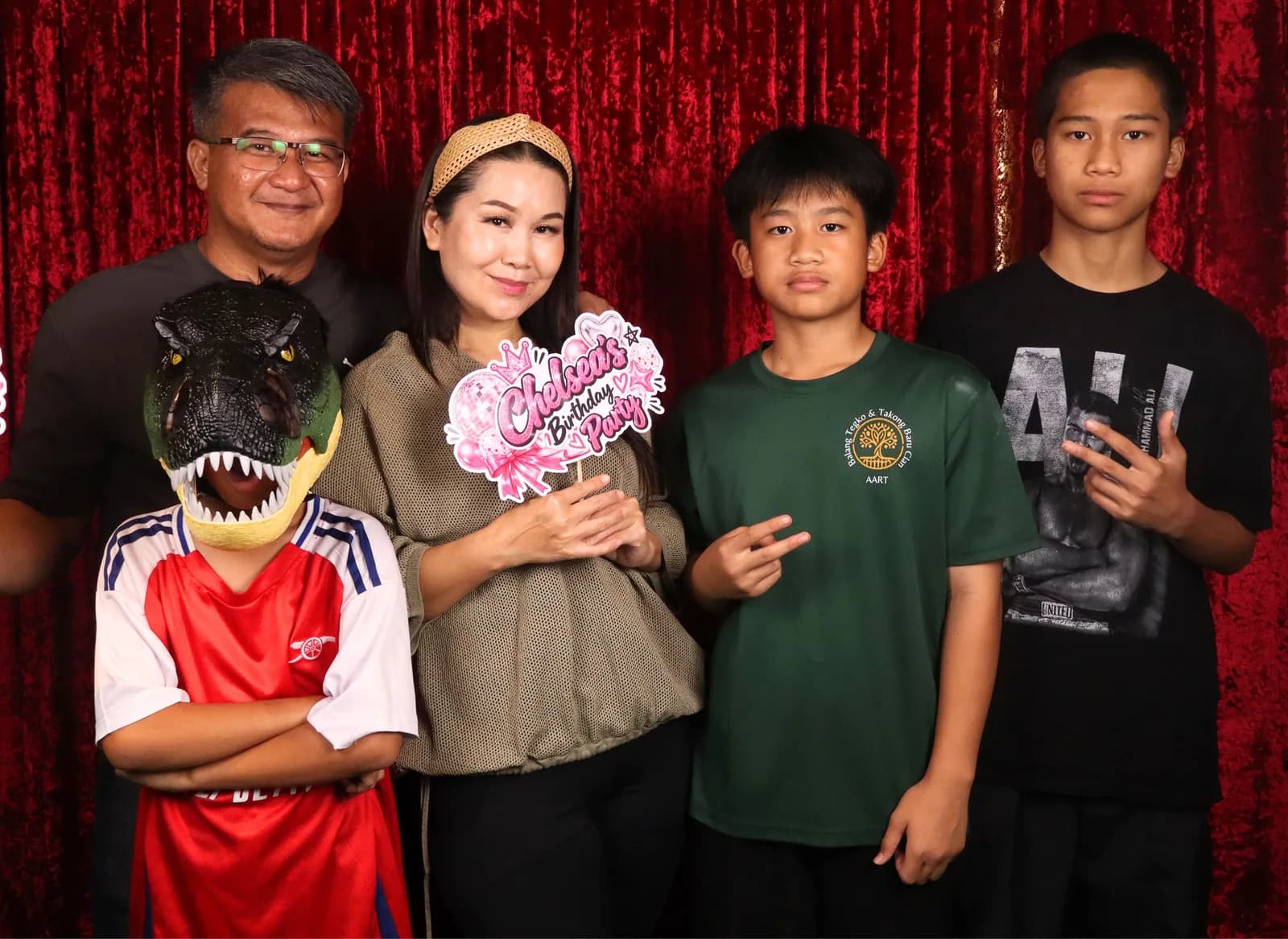 A family posing with a customized Chelsea birthday party prop