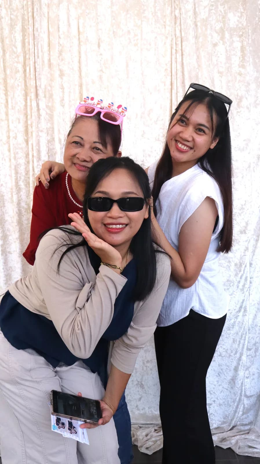 Three friends posing with birthday glasses at a Nezco On-Site event