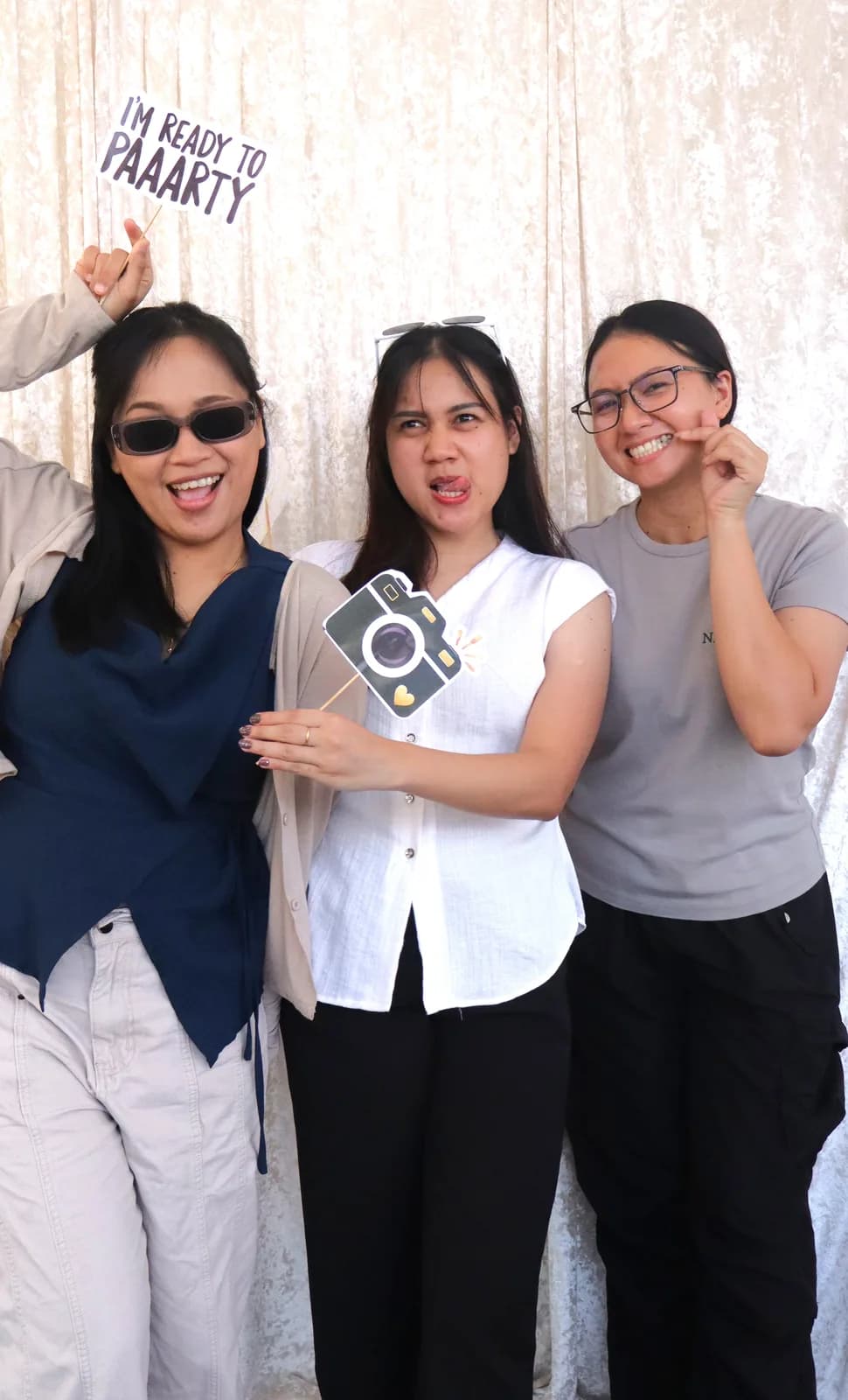 Friends making playful expressions with Nezco photo booth props
